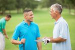 Business colleagues playing round of golf on green course