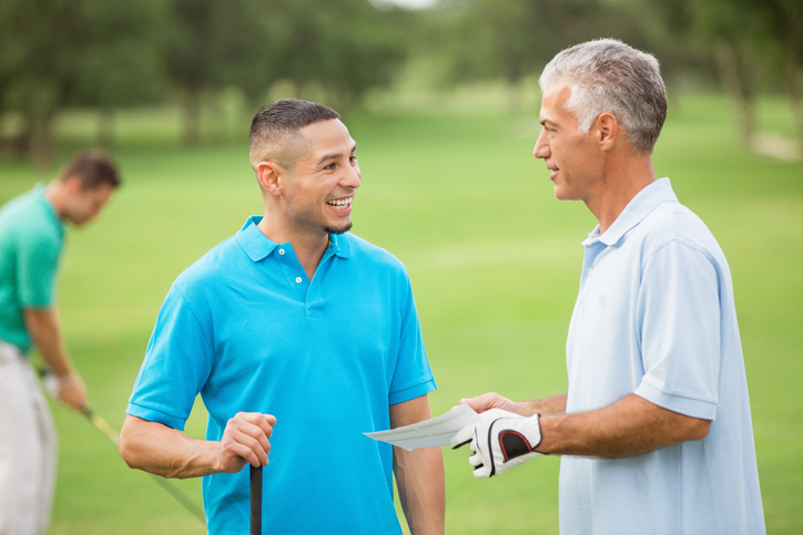 Business colleagues playing round of golf at Waterfront Country Club