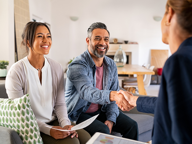 couple shake hands with the real estate agent